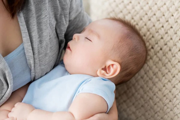 Close up of mother holding sleeping asian baby boy — Stock Photo, Image