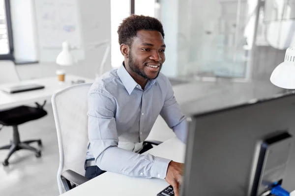 Empresario africano trabaja con computadora en la oficina —  Fotos de Stock
