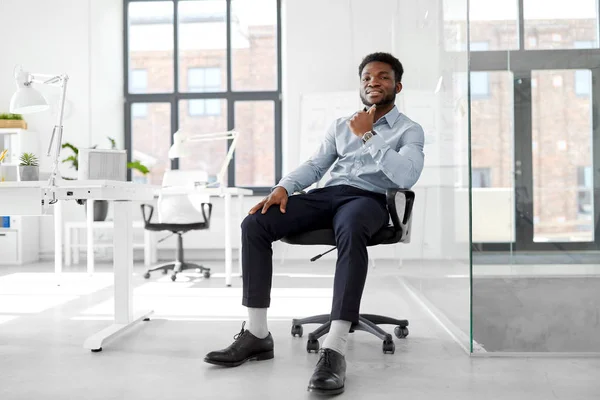 Homme d'affaires africain assis sur une chaise de bureau — Photo