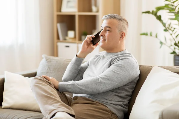 Homme heureux appelant sur smartphone à la maison — Photo