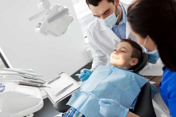 Dentista verificando dentes de criança na clínica odontológica — Fotografia de Stock