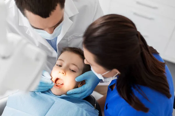 Tandläkare som kontroll för kid tänder på tandvårdsklinik — Stockfoto