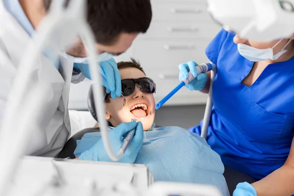 Dentista tratamiento de dientes de niño en la clínica dental — Foto de Stock