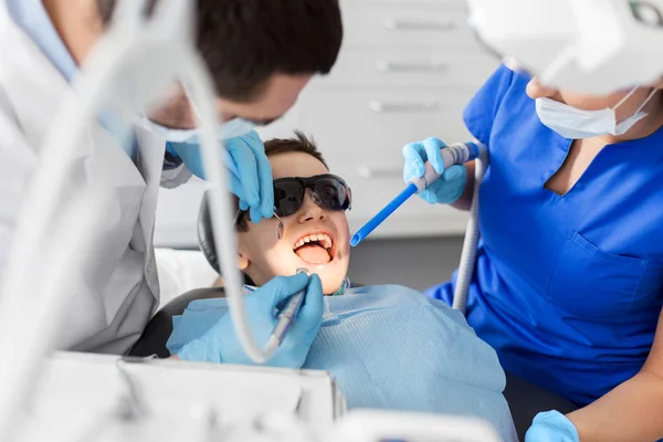 Dentiste traitant les dents d'enfant à la clinique dentaire — Photo