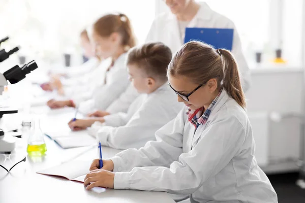 Učitel a studenti studium chemie na školách — Stock fotografie