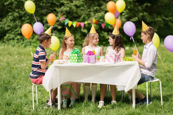 Crianças felizes na festa de aniversário no jardim de verão — Fotografia de Stock