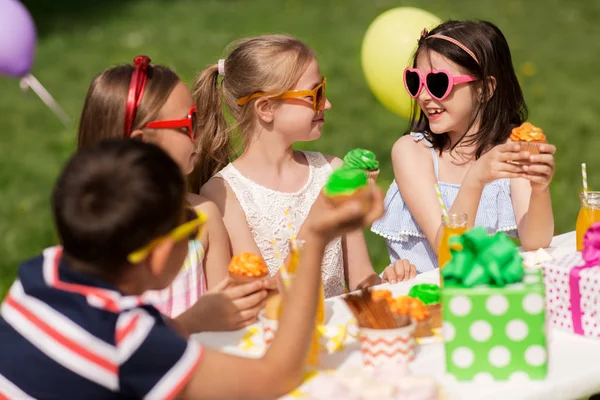 Enfants mangeant des cupcakes à la fête d'anniversaire en été — Photo