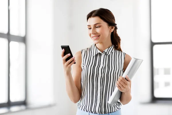 Businesswoman with smartphone and folder at office — Stock Photo, Image