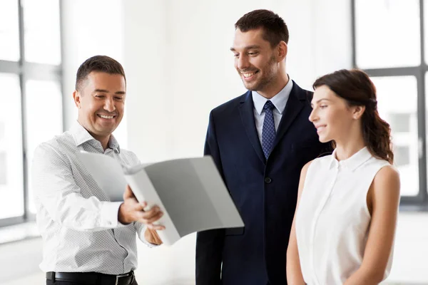 Realtor with folder showing documents to customers — Stock Photo, Image