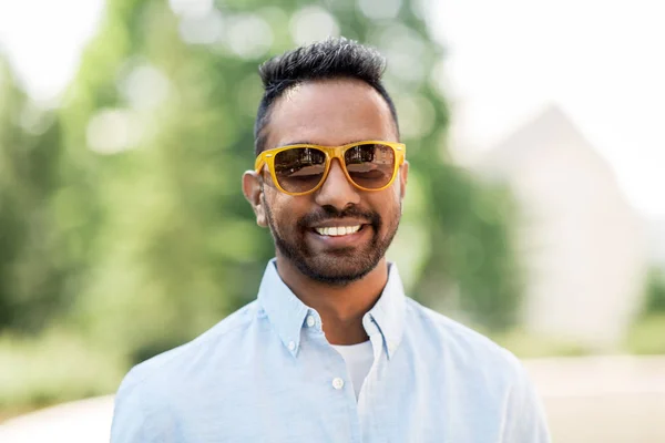 Heureux jeune homme indien dans des lunettes de soleil à l'extérieur — Photo