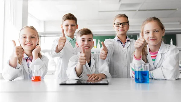 Glada barn visar tummen på skolan laboratorium — Stockfoto