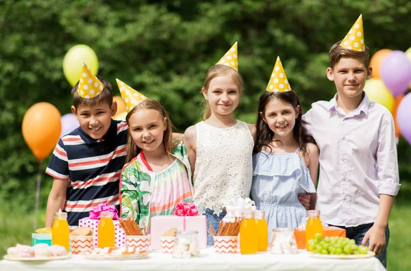 Glada barn på födelsedagsfest på sommarträdgård — Stockfoto