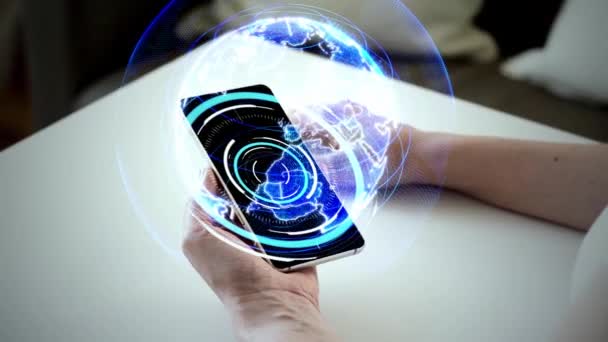 Руки и смартфон с виртуальной земной голограммой — стоковое видео