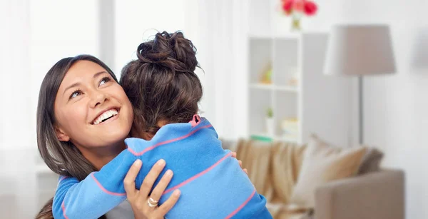 Счастливая мать и дочь обнимаются дома — стоковое фото