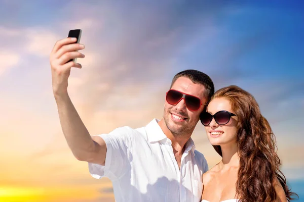 Smiling couple making selfie by smartphone — Stock Photo, Image