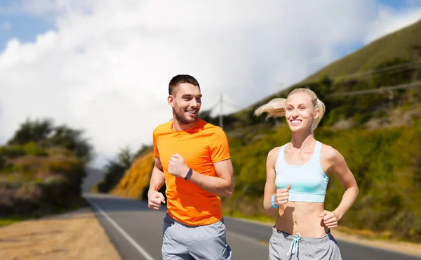 Sonriente pareja corriendo sobre grandes colinas sur —  Fotos de Stock