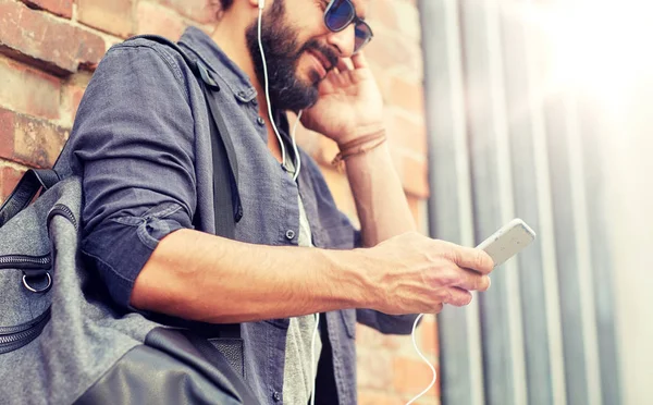 Mann mit Kopfhörer, Smartphone und Tasche auf der Straße — Stockfoto