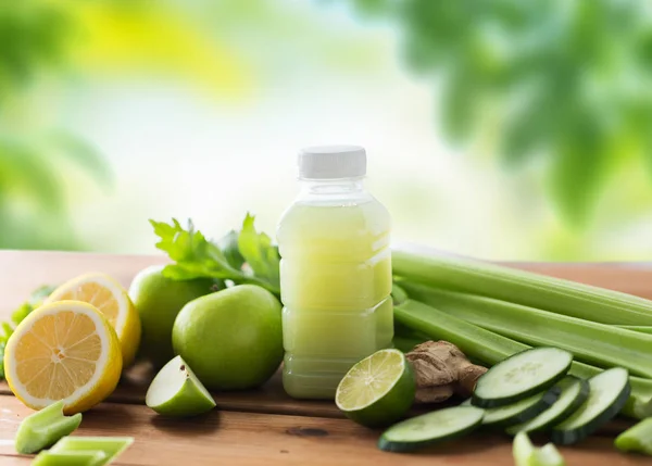 Close up of bottle with green juice and vegetables — Stock Photo, Image