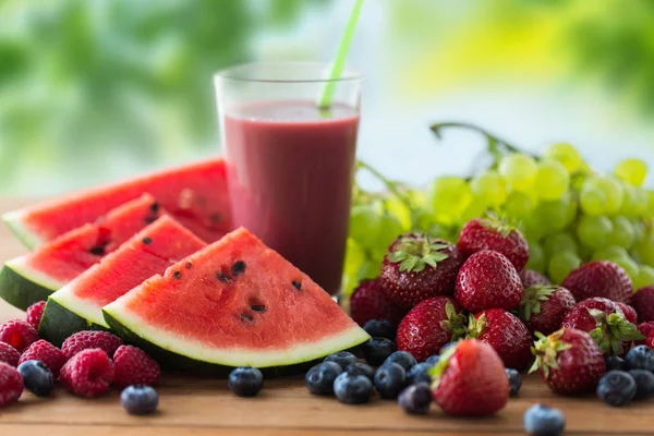 Zumo de frutas y bayas o batido sobre mesa de madera — Foto de Stock