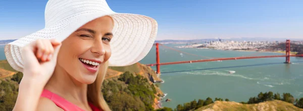 Femme en chapeau de soleil sur pont porte dorée — Photo