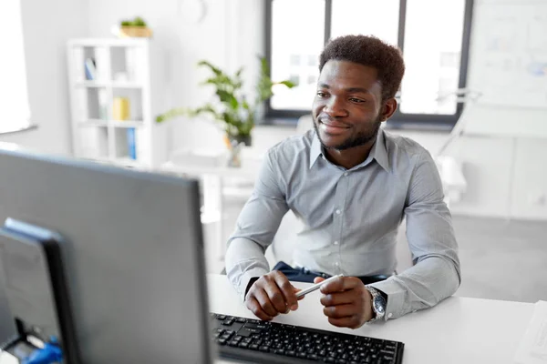 Африканський бізнесмен працює з комп'ютером в офісі — стокове фото