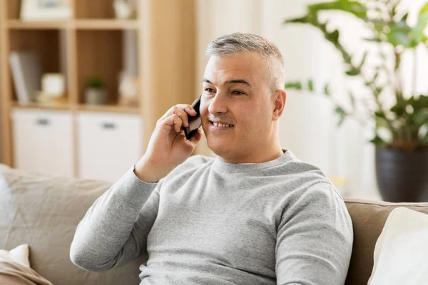 Homem feliz chamando no smartphone em casa — Fotografia de Stock