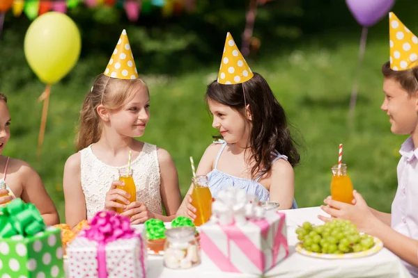 Glada barn på födelsedagsfest på sommarträdgård — Stockfoto