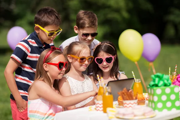 Glada barn med TabletPC på födelsedagsfest — Stockfoto