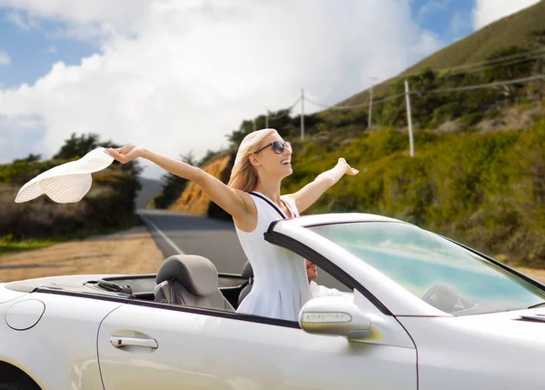 happy couple driving in convertible car