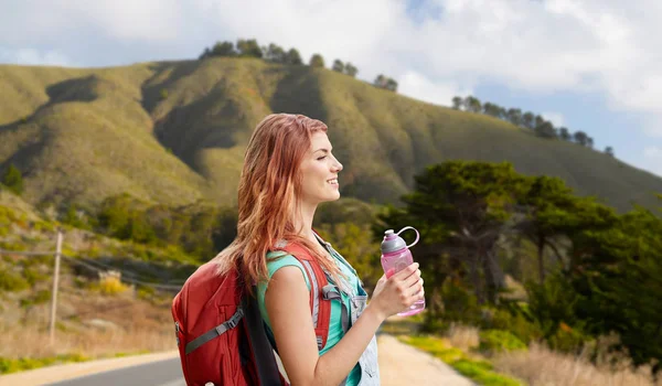 Big sur tepelerde sırt çantası ile gülümseyen kadın — Stok fotoğraf