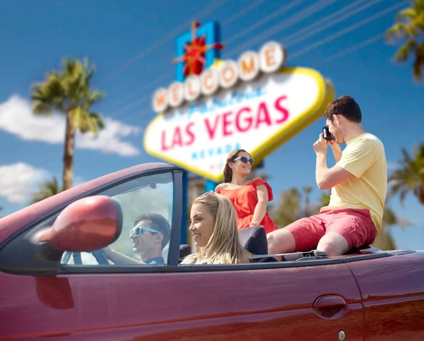 Friends with camera driving in car at las vegas — Stock Photo, Image