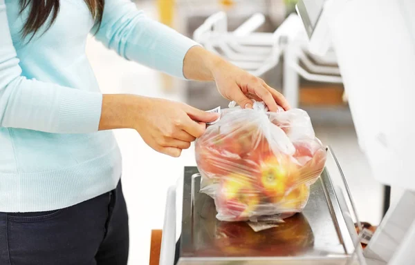 Frau wiegt Äpfel auf Waage im Lebensmittelgeschäft — Stockfoto