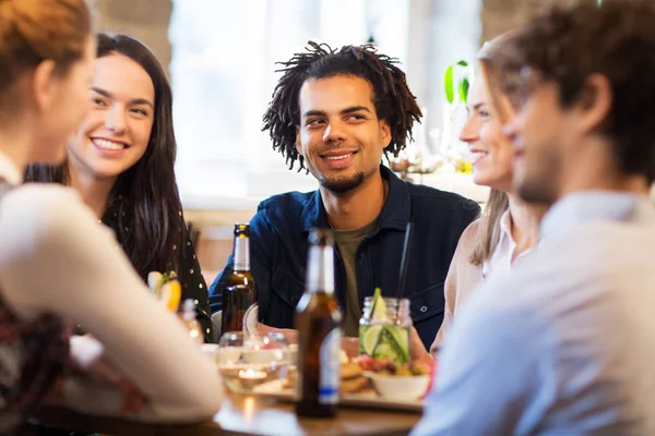 Happy friends eating at bar or restaurant — Stock Photo, Image