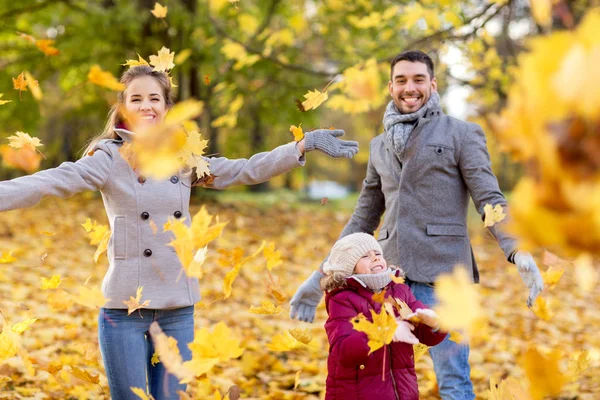 Glückliche Familie spielt im Park mit Herbstlaub — Stockfoto