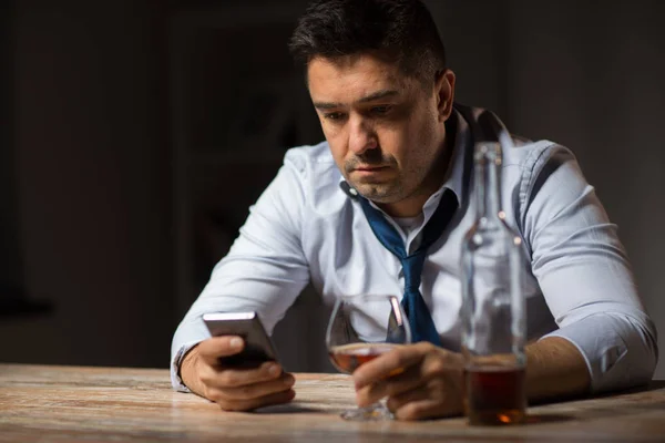 Berusad man med smartphone och alkohol på natten — Stockfoto