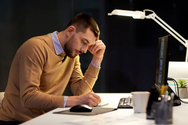 Hombre con bloc de notas trabajando en la oficina nocturna —  Fotos de Stock