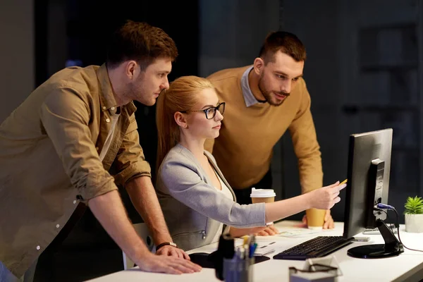 Business team with computer working late at office — Stock Photo, Image