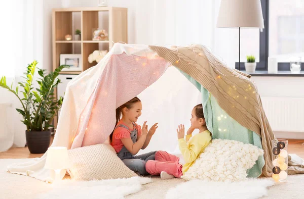 Girls playing clapping game in kids tent at home — Stock Photo, Image