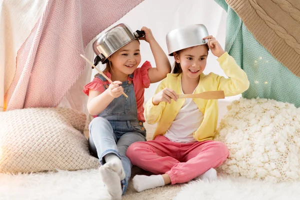 Girls with kitchenware playing in tent at home — Stock Photo, Image