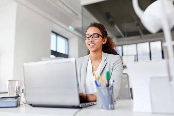 Happy businesswoman with laptop working at office — Stock Photo, Image