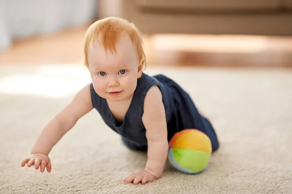 Linda menina ruiva com bola de brinquedo em casa — Fotografia de Stock