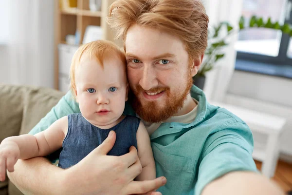 Счастливый отец с ребенком делает селфи дома — стоковое фото