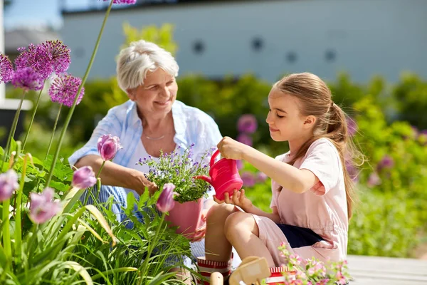 Abuela y niña plantando flores en el jardín — Foto de Stock