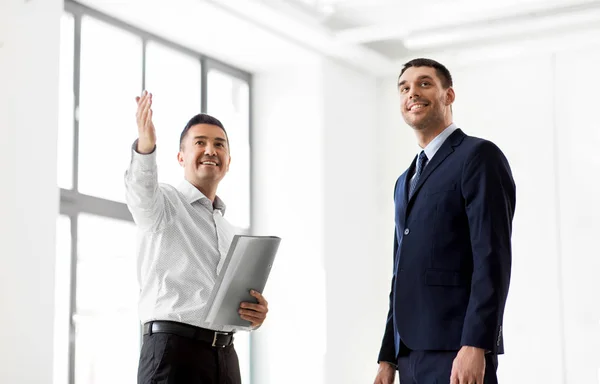 Makler mit Ordner, der dem Kunden neues Büro zeigt — Stockfoto