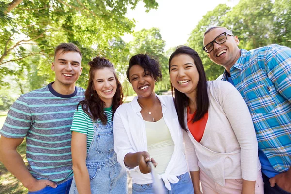 Grupo de amigos internacionais felizes tomando selfie — Fotografia de Stock