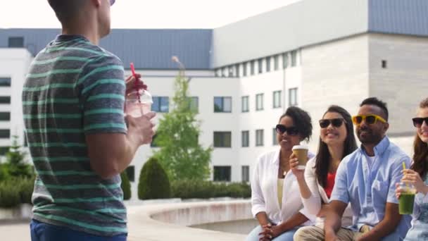 Amigos bebendo café e suco falando na cidade — Vídeo de Stock