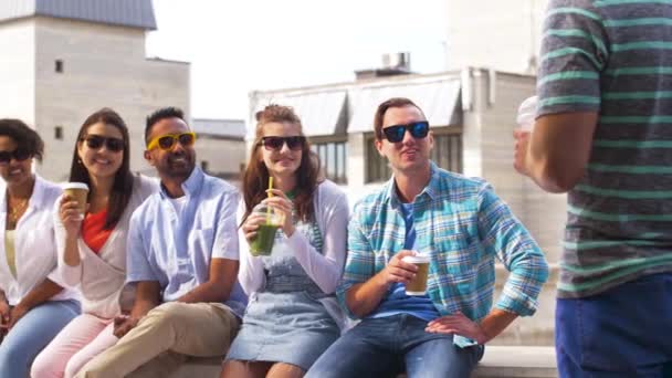 Amici che bevono caffè e succo di frutta parlando in città — Video Stock