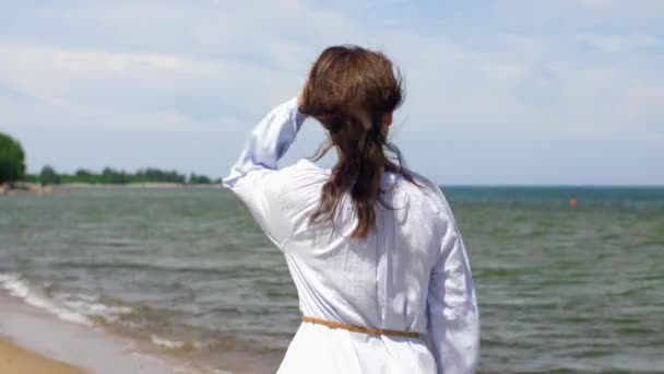 Lyckligt leende kvinna promenader längs sommar strand — Stockvideo