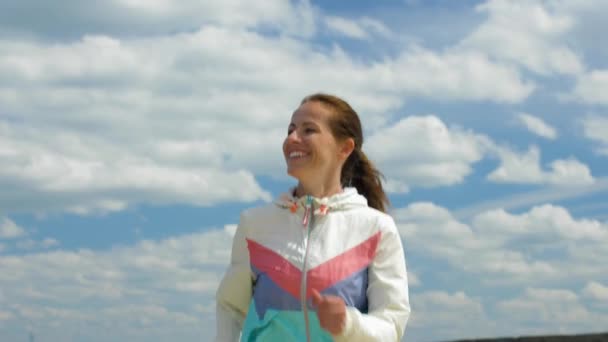 Χαμογελαστή γυναίκα που τρέχει κατά μήκος της παραλίας — Αρχείο Βίντεο