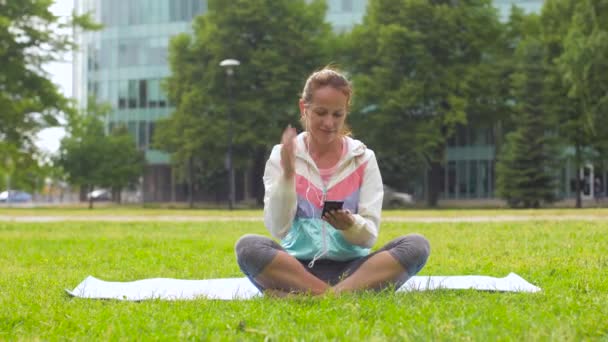 Mujer con smartphone poniendo música para la meditación — Vídeo de stock